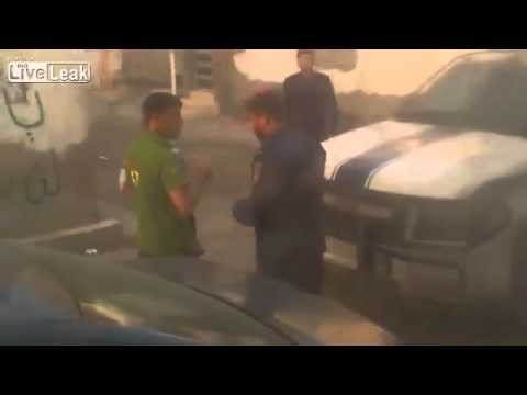 Policjant z Bahrainu policzkuje faceta trzymajacego dziecko